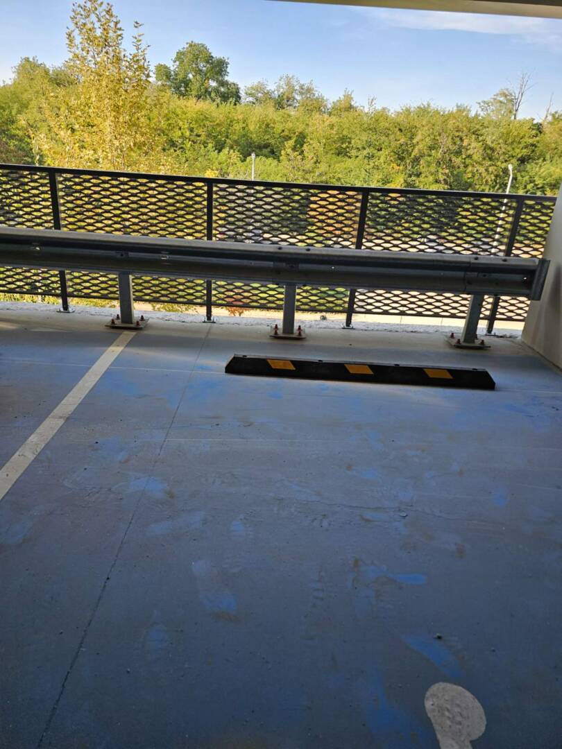 Opritor parcare negru-galben din cauciuc pe pardoseală albastră Opritor parcare din cauciuc cu benzi reflectorizante galbene
